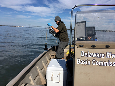 DRBC staff collect a water sample from the Delaware Estuary to monitor for microplastics. Photo by DRBC.