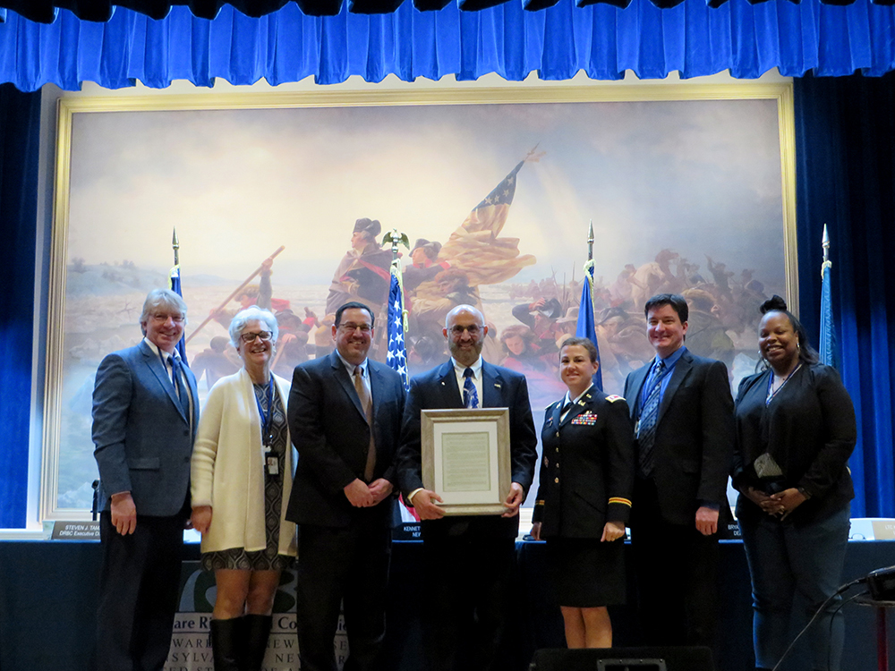 Dr. Najjar poses with Steve Tambini and the Commissioners.  (from L to R) Kenneth Kosinski (alternate, N.Y.), Michele Putnam (alternate, N.J.), Steve Tambini (DRBC Exec. Dir.), Dr. Najjar, Lieutenant Colonel Kristen N. Dahle (alternate, federal gov't.), Bryan A. Ashby (alternate, Del.), and Aneca Atkinson (alternate, Pa.). 