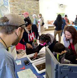 DRBC's Jake Bransky looks on as kidscheck out the macros displays. Eventhe adults were interested in what isliving in our local creeks & streams!Photo by the DRBC.