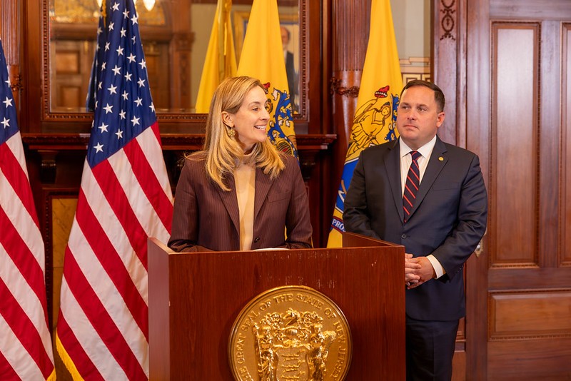 Governor Sherrill speaking at a podium with Commissioner Solomeno standing next to her (right side) 
