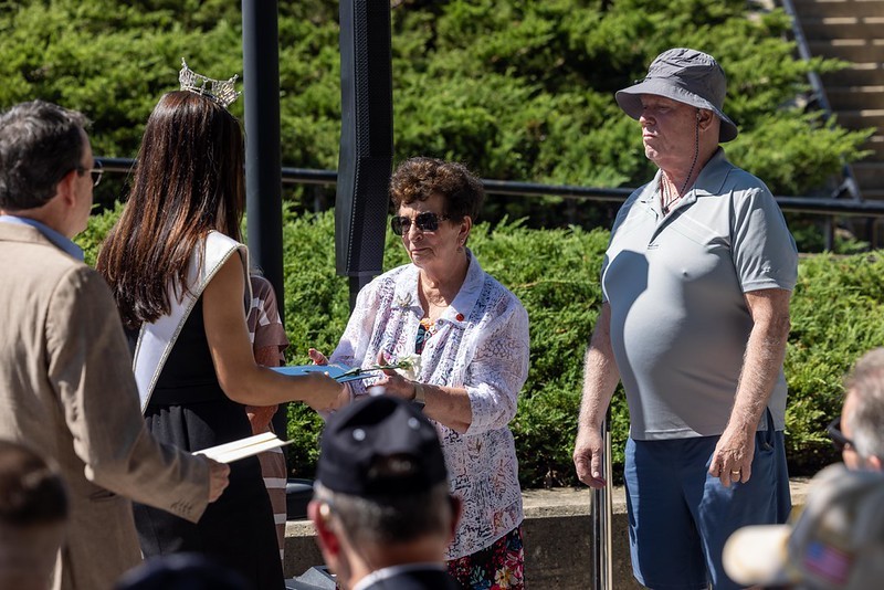 A loved one of a NJ Veteran whose name does not appear on the Memorial Wall recieving flowers.