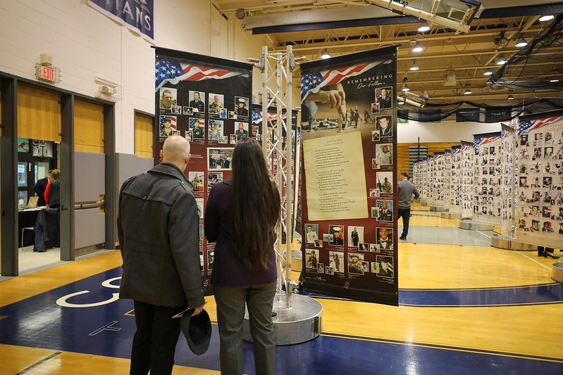 Visitors standing in front of Remembering Our Fallen photographic memorial.