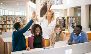 High school students gathered in a library with teacher