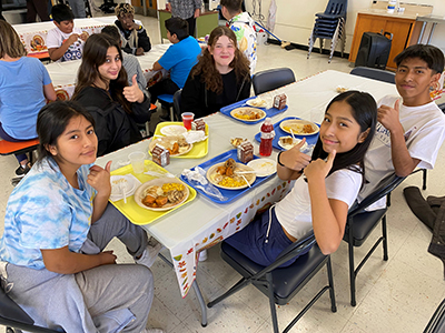 Students seated around a table eating lunch