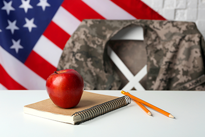 classroom setting with American flag in the background and a military uniform draped on the teachers chair