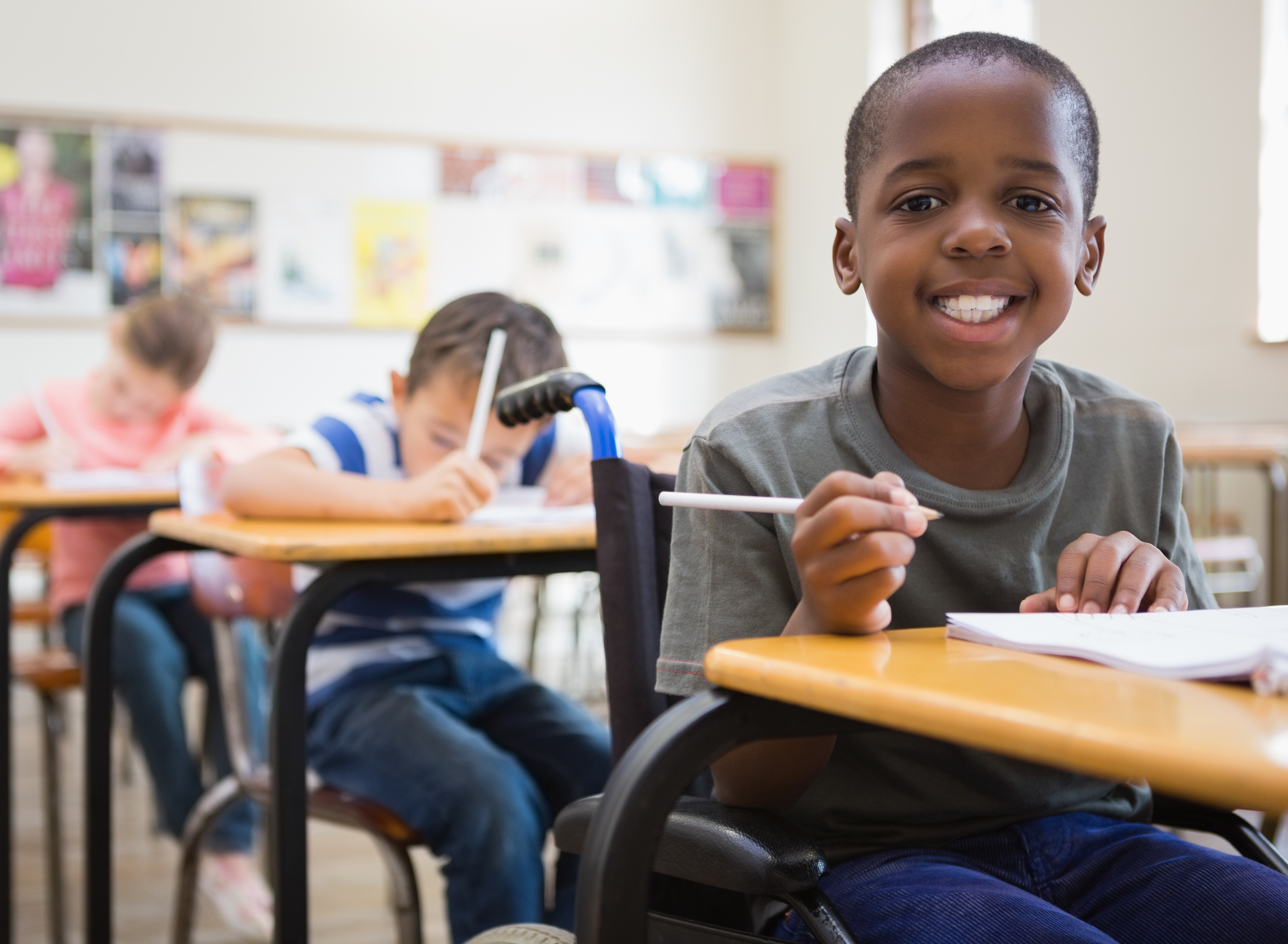 Student in wheelchair smiling in an inclusion classroom