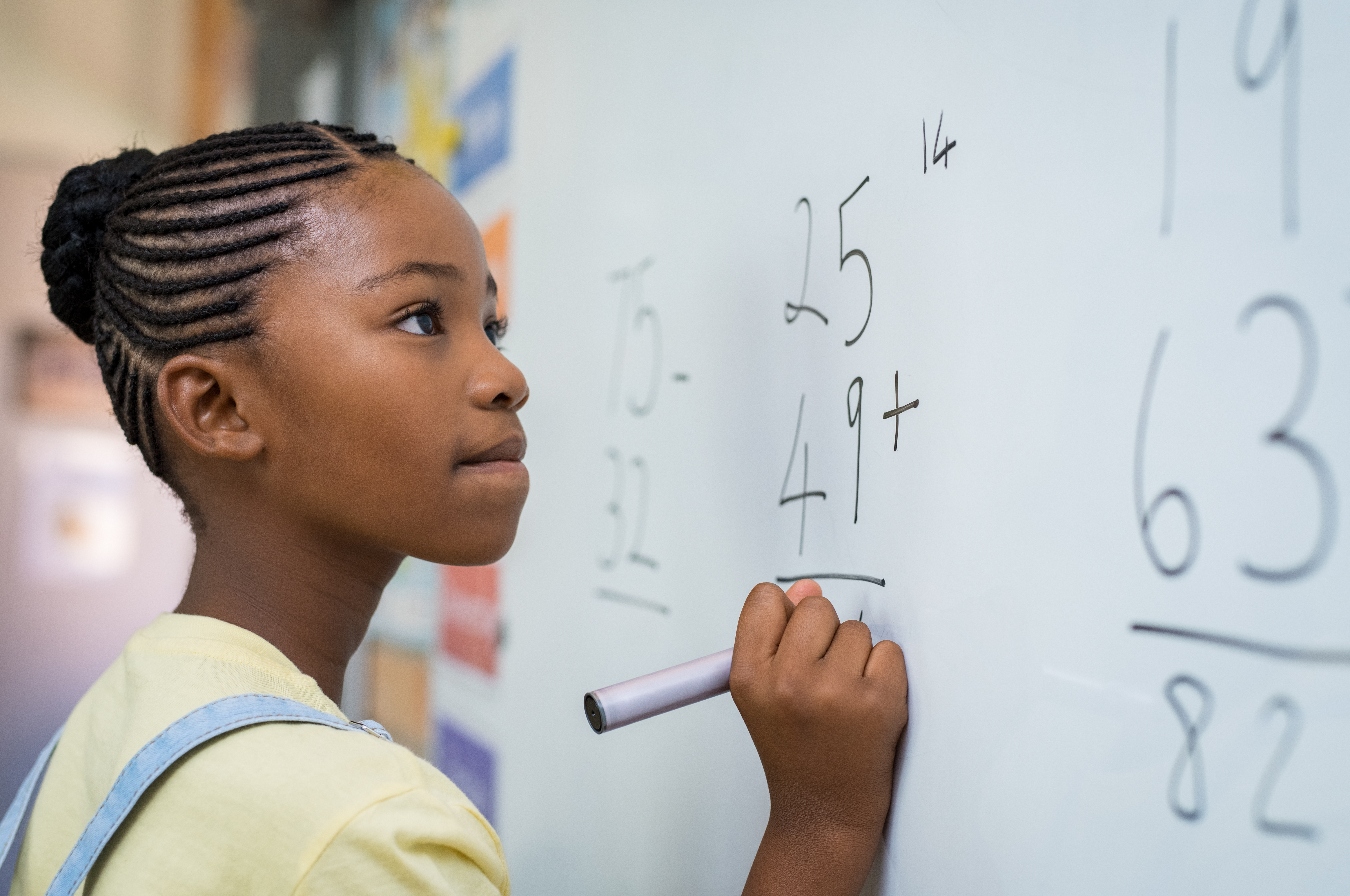 Middle school age girl doing math at the white board