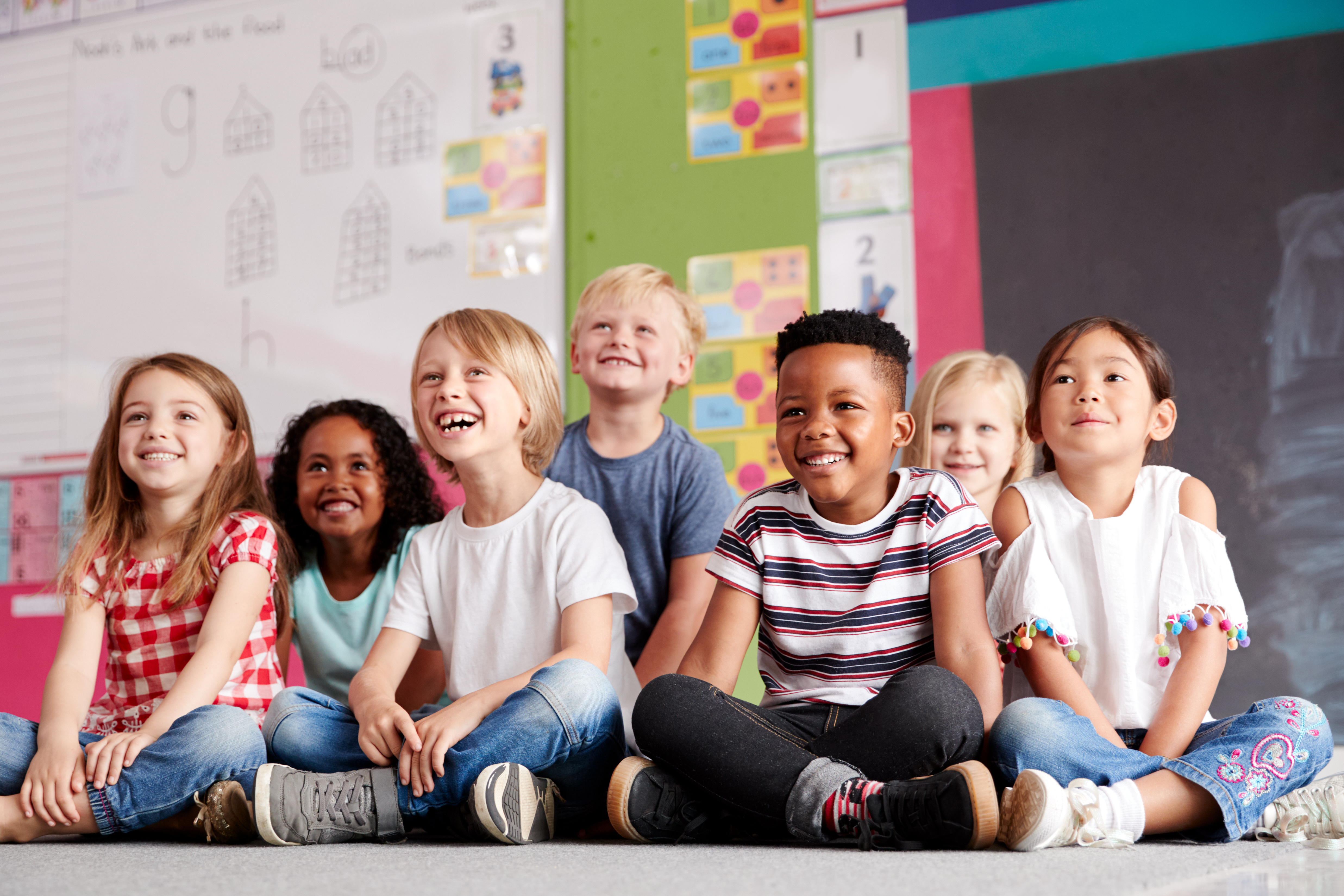 Elementary students sitting on the floor in a classroom