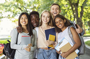 High school students posing outdoors, holding books