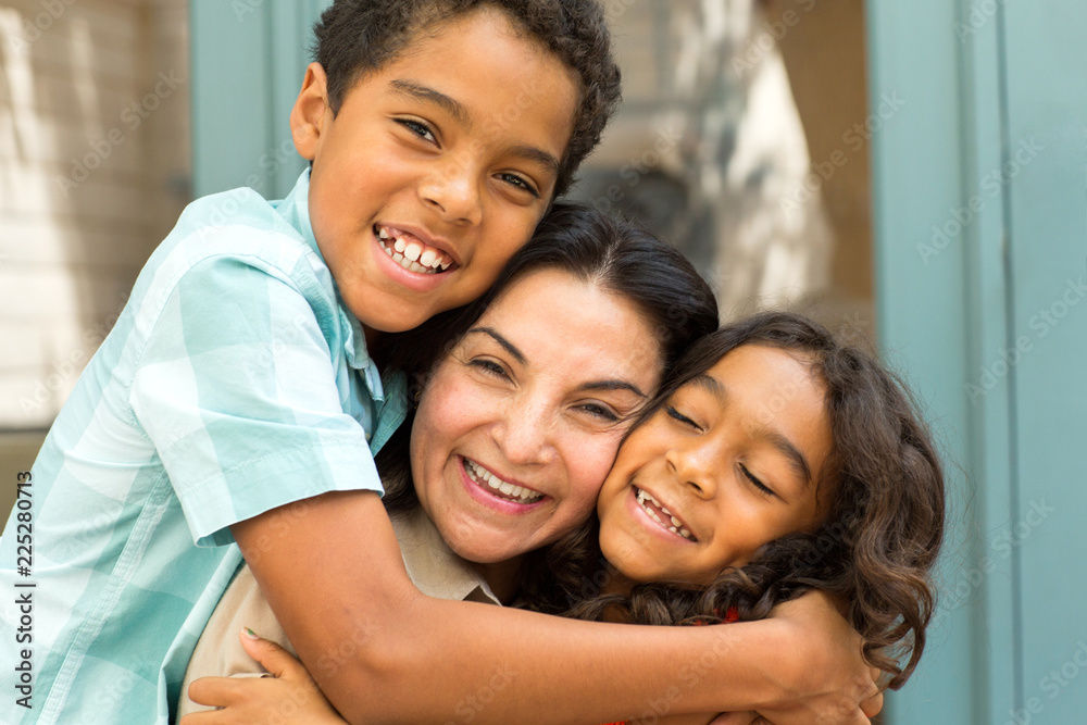 Happy Hispnaic mother laughing and talking with her children.