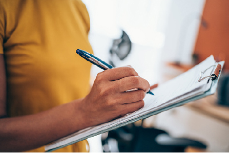 Woman writing on a clipboard