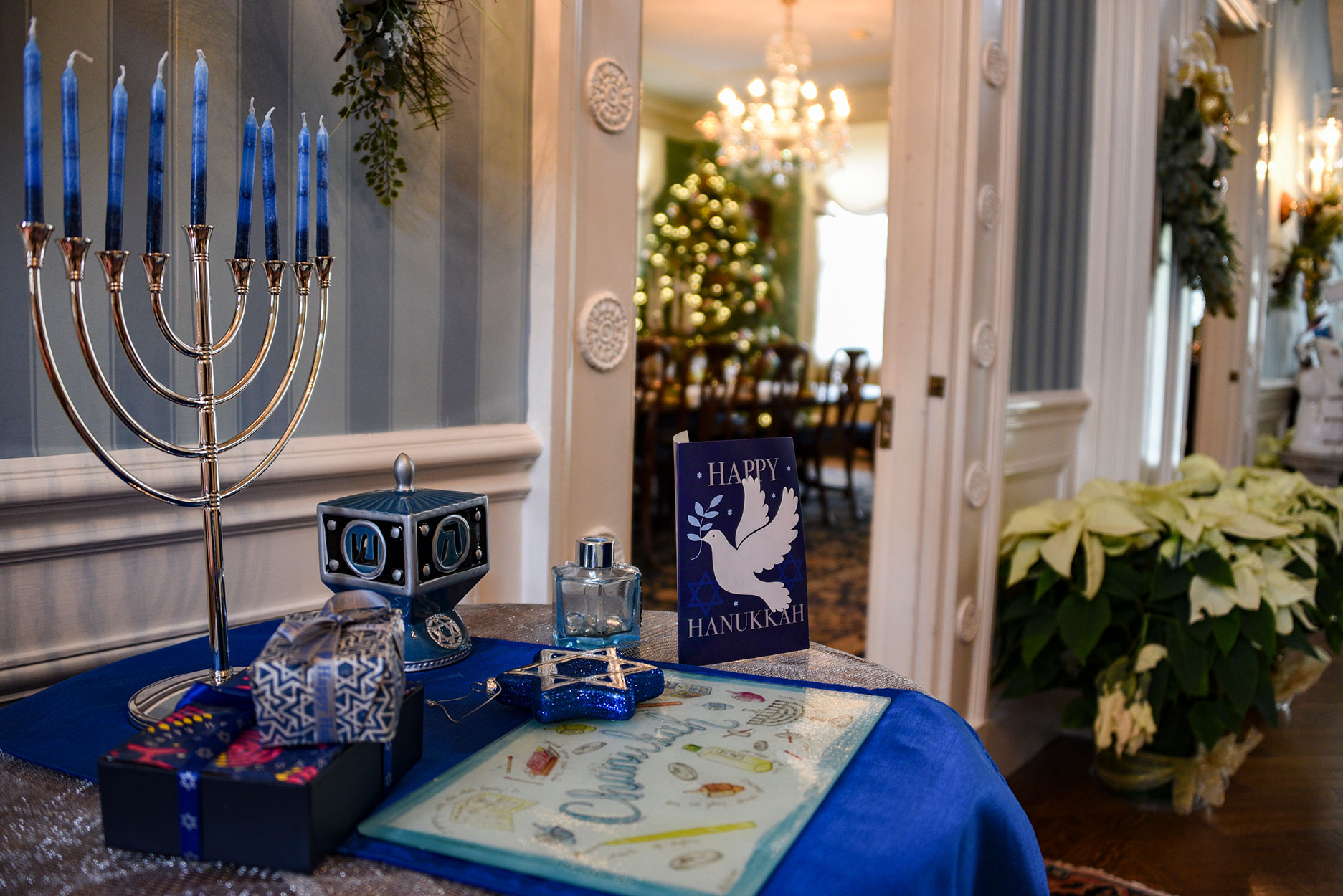 jpg   Drumthwackets welcoming Foyer, featuring a Menorah honoring Chanukah, on a sideboard at a doorway to the Dining Room. Decor by Keyport Garden Club.