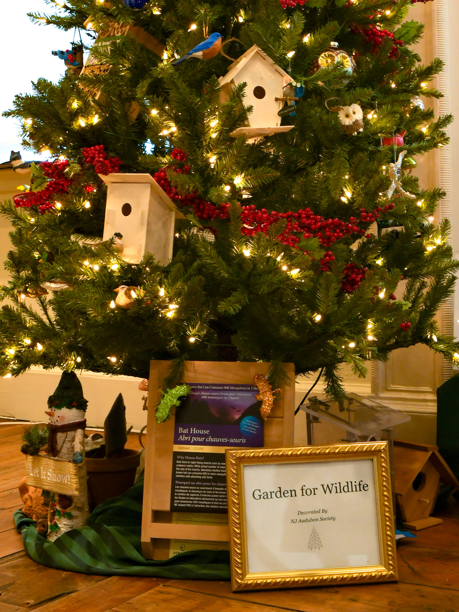 Close view of the New Jersey Audubon Societys “Garden for Wildlife” tree. Birdhouses, berries and bird ornaments are all around.