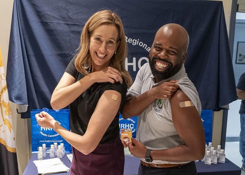 Governor Mikie Sherrill and Health Commissioner Dr. Raynard Washington showing bandage on their arms after vaccine