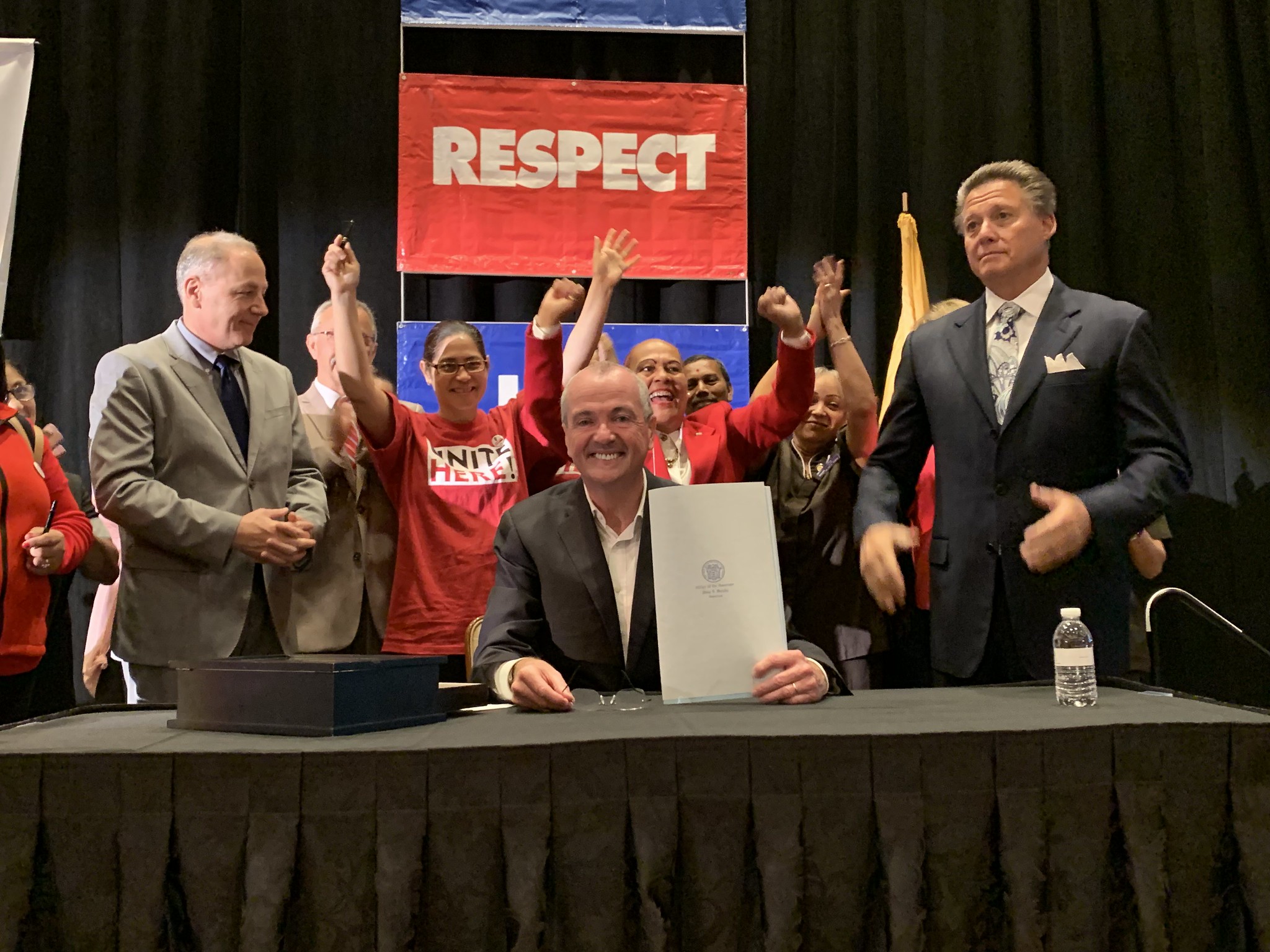 Photo of Governor Phil Murphy holding bill documents that he had just signed.