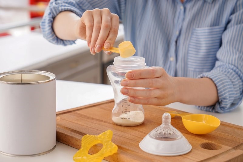 photo: women hands holding bottle with baby formula