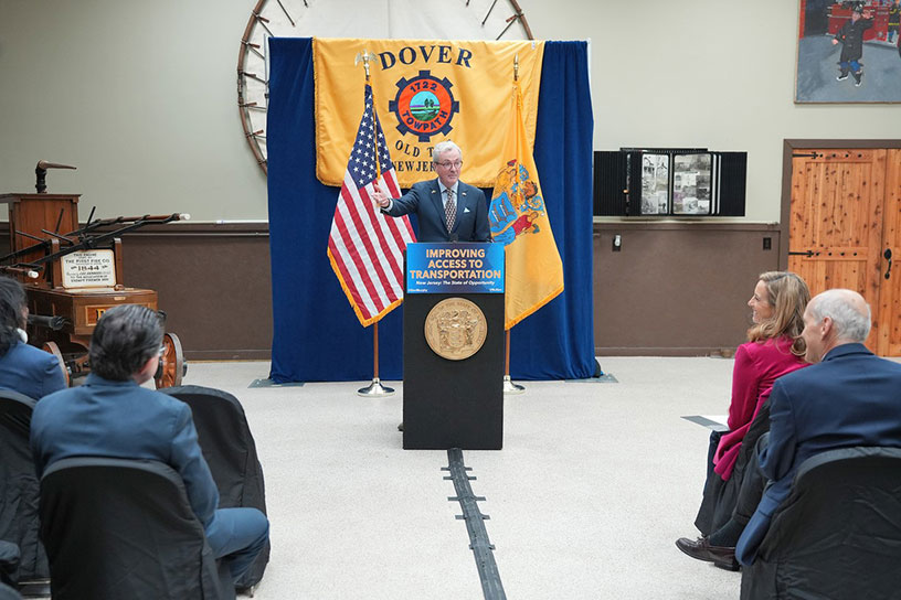 photo: Governor Phil Murphy speaking , Dover Township sign behing him