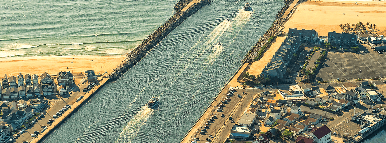 Four boats leaving a New Jersey inlet on a sunny day.