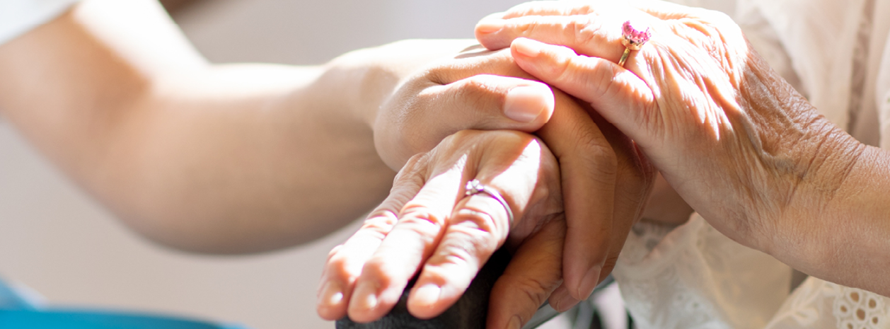 Close-up of two women holding hands.