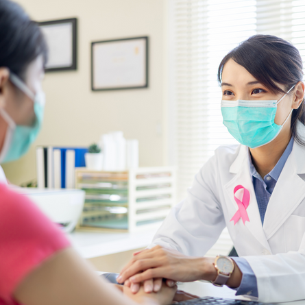 Health care provider in a mask comforting a patient.