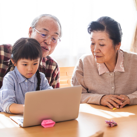 Grandparents and grandchild looking at a computer