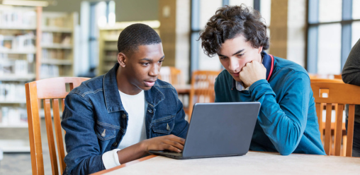 Two people looking at a laptop