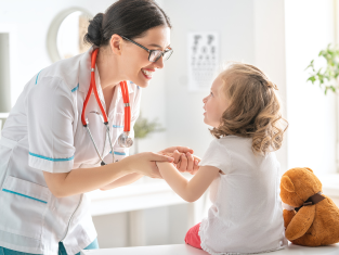 Smiling doctor taking care of little girl