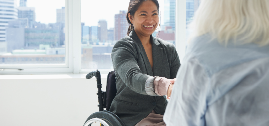 Two women shaking hands and smiling