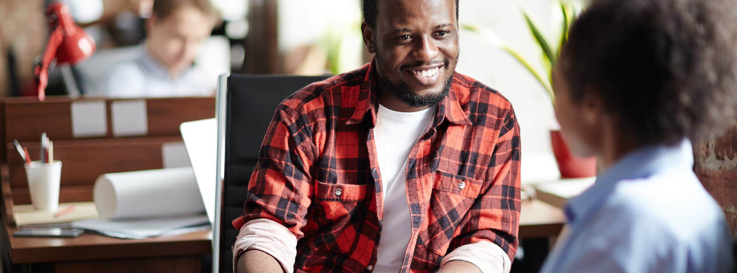 Man is sitting in front of a woman at the table and smiling