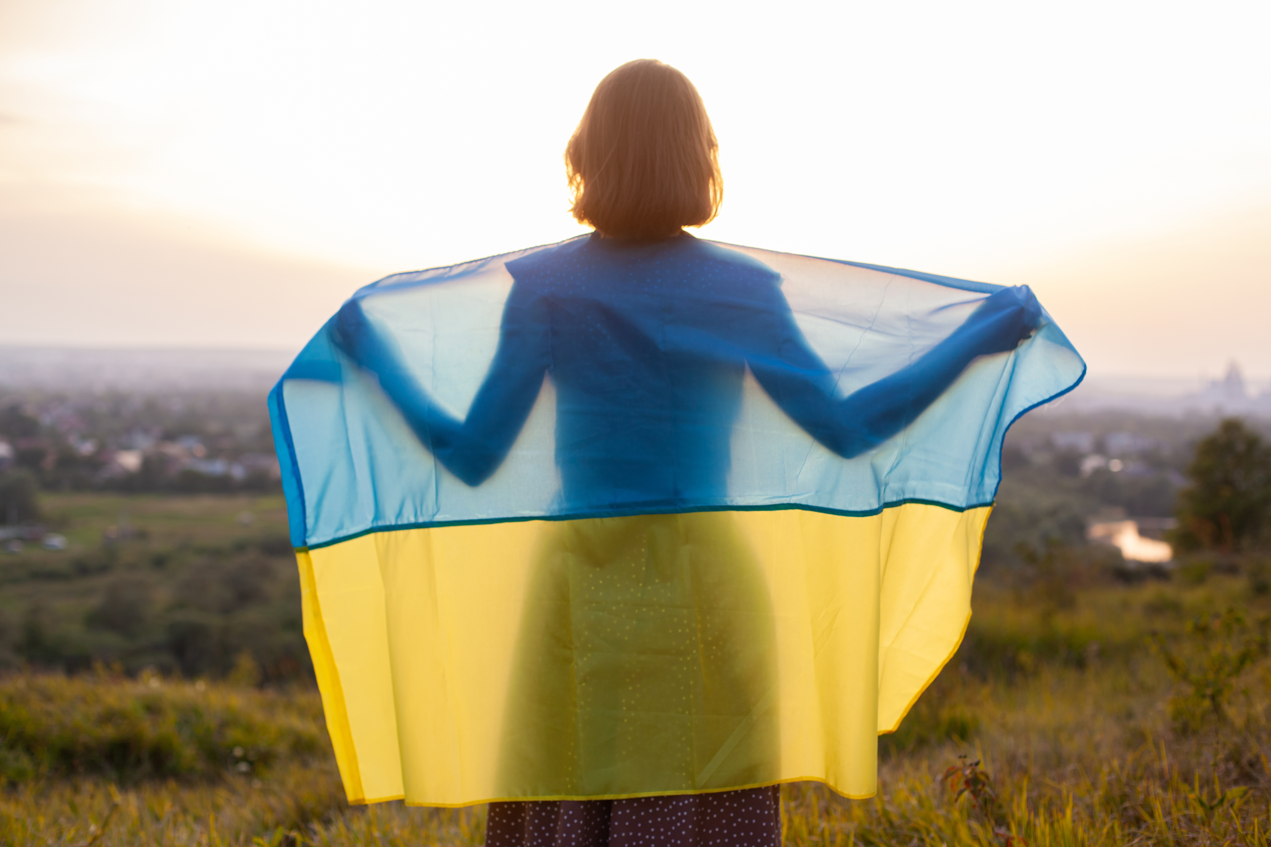  Woman is holding Ukrainian flag in the meadows