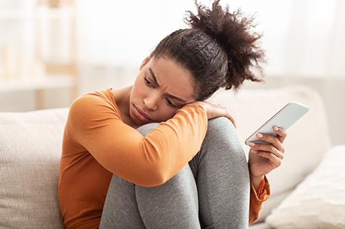 photo: woman sitting on the floor, holding mobile phone