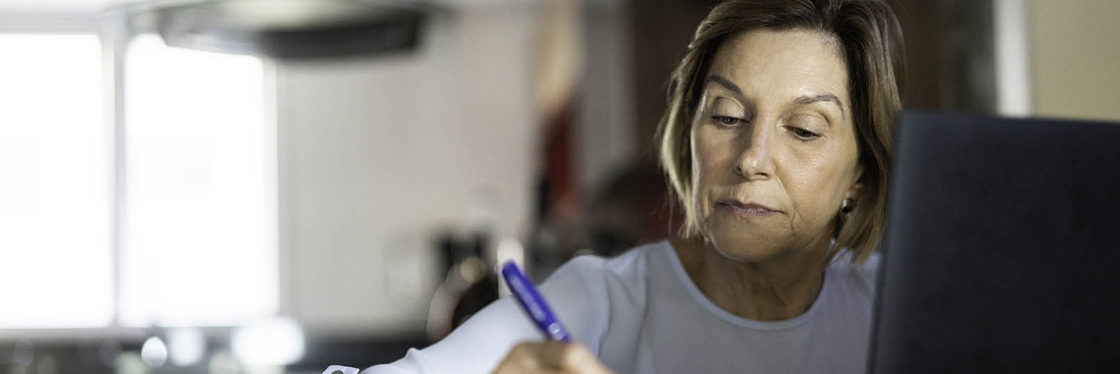 woman looking pensive at her kitchen table