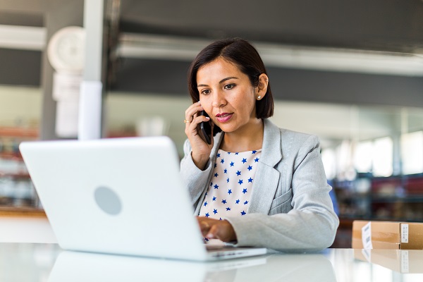 Woman at laptop on smart phone.