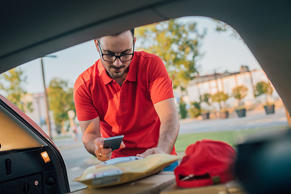 delivery driver getting a package out of his car