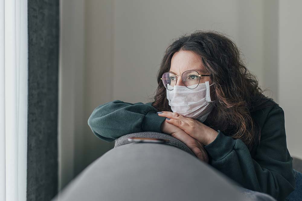 a woman wearing a mask at home