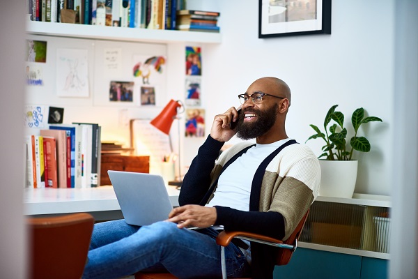 Man at desk talking on cell phone