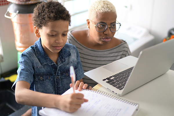 a Black mother and child working on virtual distance learning at home