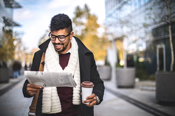 Man reading the newspaper outside