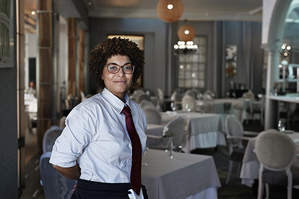 a waitress standing in the dining room of an upscale restaurant