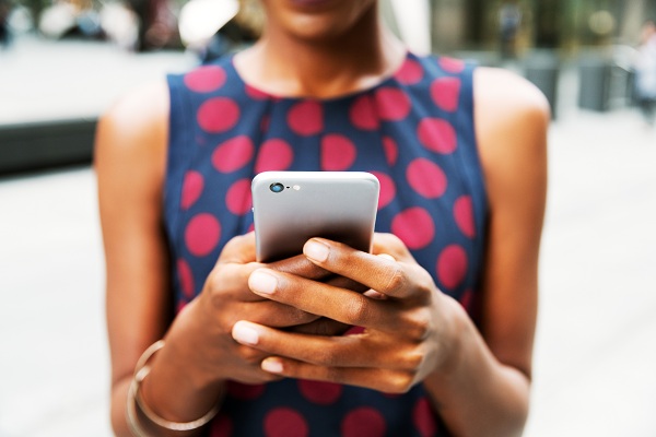a woman holding a cell phone in both hands in front of her, texting