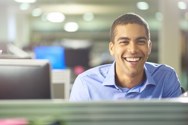 Young man smiling at desk