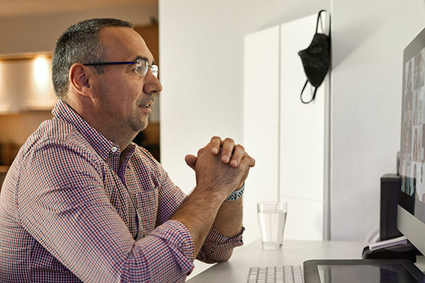 a man sitting in front of his computer at home