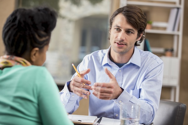 Man sitting across desk from a woman