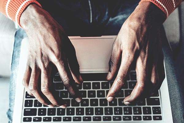 man's hands typing on a computer keyboard