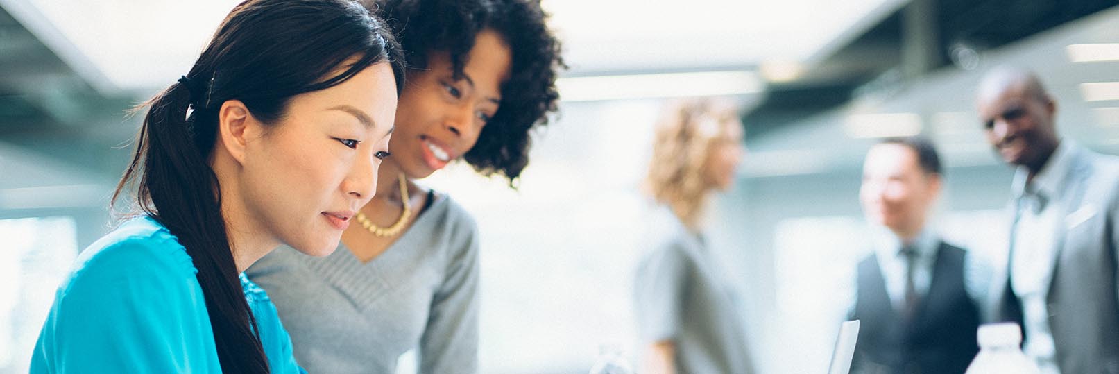 picture of two women in an office working together at a computer