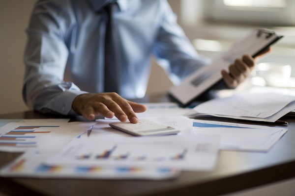 Man at desk using calculator