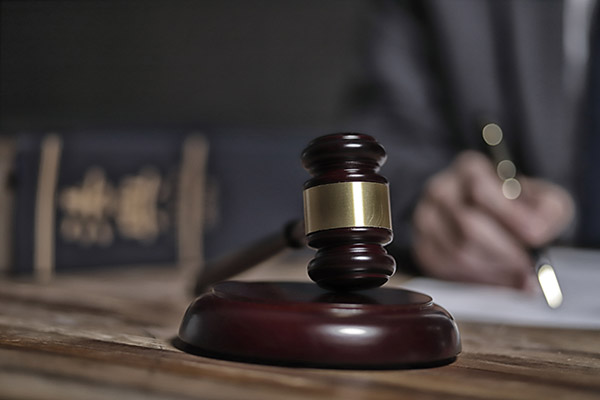 a lawyer writing legal documents with a gavel on the table