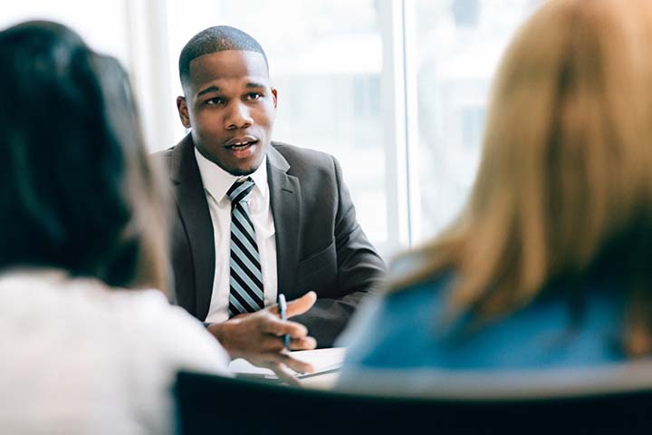 field auditor sitting at a desk talking to people