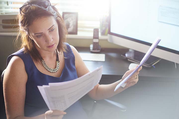 woman looking at letters in her office