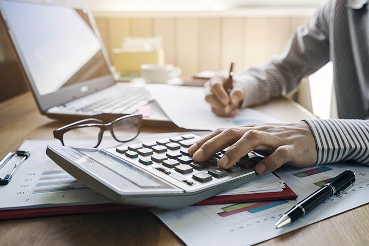 man using a calculator at a desk